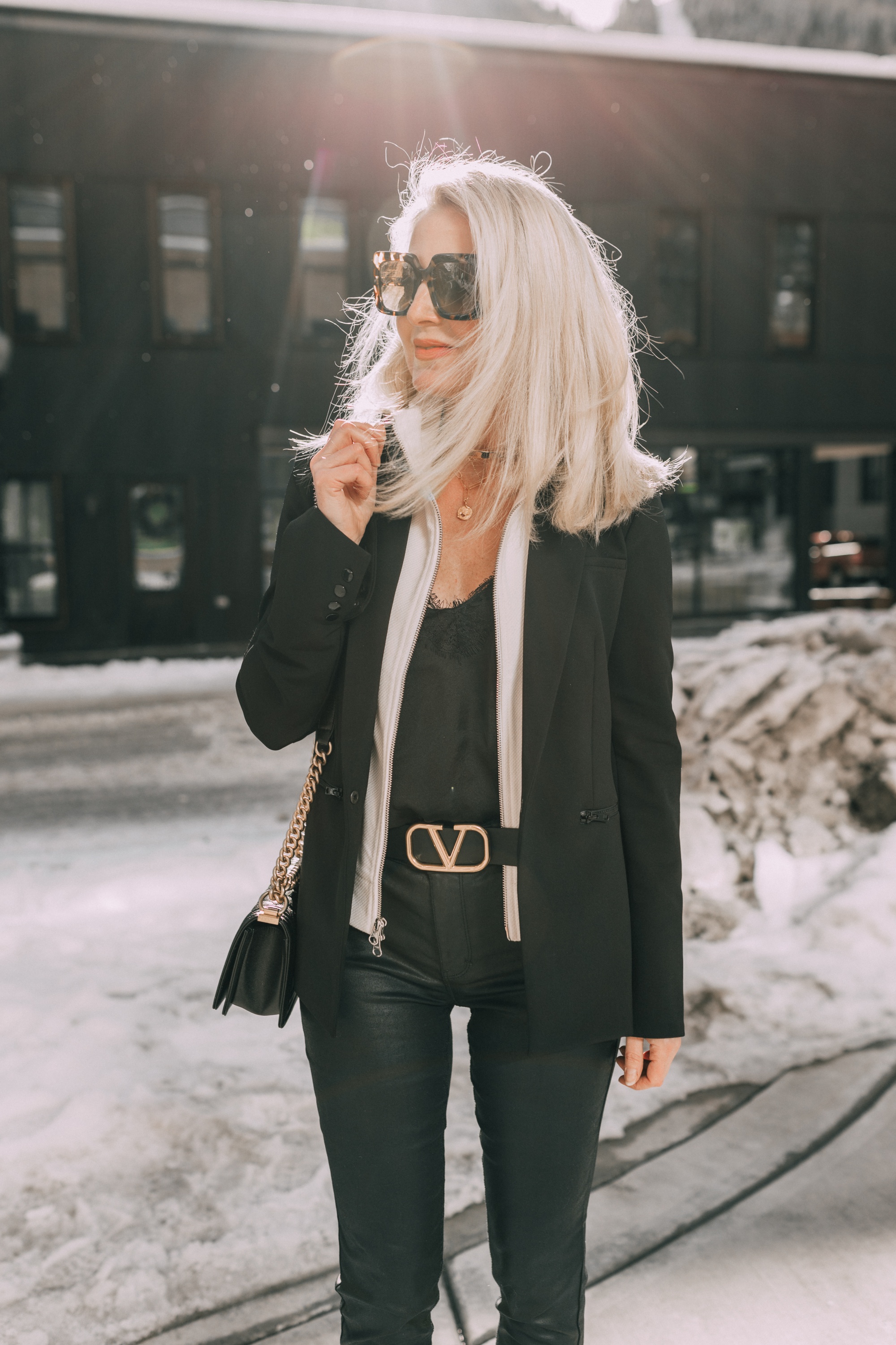 black Veronica Beard blazer date night outfit with ivory blazer dickey, black lace cami, gold valentino belt black jeans